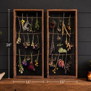 May include: Two rectangular dark brown wooden frames with three horizontal jute twine strings each, used for hanging dried flowers. The frames measure 28 inches in height and 11 inches in width each, displaying various colorful dried botanical stems.