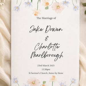 Könnte beinhalten: Eine rechteckige Hochzeitseinladungskarte mit weißem Hintergrund und Aquarell-Blumenillustrationen in Blau und Pfirsich oben und unten. Der Text lautet: The Marriage of Jake Dowen & Charlotte Marlborough 23rd March 2025 13:30pm St Saviour's Church, Aston-by-Stone.