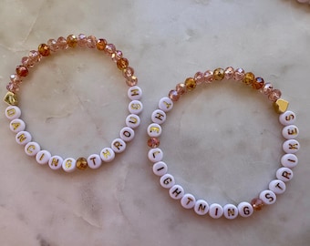 Pulsera inspirada en la vida de una corista, "Bailando entre relámpagos" (Juego de 2): Cuentas de cristal, detalles chapados en oro de 14 quilates y ópalo.