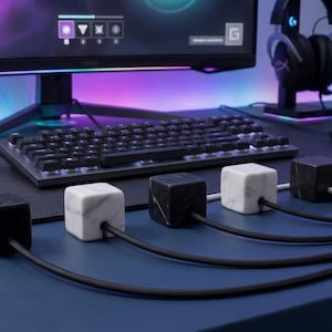 May include: A trio of ceramic mugs with a speckled, matte finish in cream, light grey, and dark grey. Each mug features a minimalist design and a rounded handle.