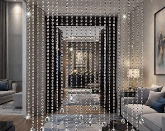 May include: A beaded curtain made of clear, sparkling crystal beads hangs in a doorway. The beads are strung in vertical strands, creating a shimmering effect. The curtain adds a touch of elegance and glamour to the interior space.