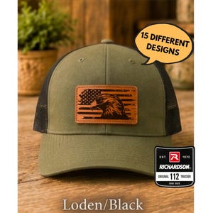Puede incluir: Una gorra trucker verde oliva y negra con un parche de cuero rectangular que presenta un diseño grabado con láser de un águila y una bandera estadounidense. Un globo de texto dice 15 DIFFERENT DESIGNS y una etiqueta dice RICHARDSON ORIGINAL 112 TRUCKER.
