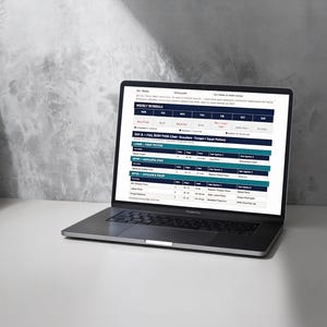 Peut inclure: Un ordinateur portable argenté affichant un programme d'entraînement numérique sur son écran. Le document présente un tableau d'emploi du temps hebdomadaire avec des colonnes pour les jours et des lignes détaillant les exercices, séries et repos.
