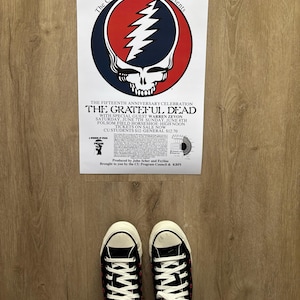 May include: A concert poster for The Grateful Dead's fifteenth anniversary celebration, featuring the band's skull and lightning bolt logo. The poster includes the text "The CU Program Council Presents" and event details. Black Converse sneakers with white laces are visible.