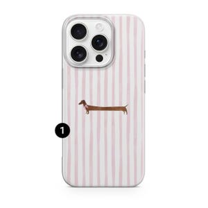 May include: Clear phone case featuring a pink and white striped design. A brown dachshund dog with a pink collar is depicted. The case has cutouts for the camera and side buttons.