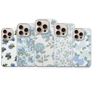 May include: Five phone cases with floral designs. The cases feature a variety of blue hydrangea patterns on a white background. The designs include full blooms, scattered flowers, and leafy stems.