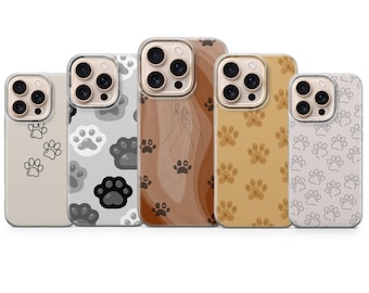 May include: A collection of phone cases with paw print designs. The cases feature various colors, including beige, gray, brown, and yellow. Some cases have solid-colored backgrounds, while others have patterned designs. The paw prints are in black, white, and brown.
