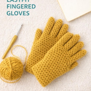 May include: Mustard yellow crocheted gloves with the text "Crochet Pattern EASYFIT FINGERED GLOVES". A ball of yarn, crochet hook, and notepad are also visible. The image is on a white surface.