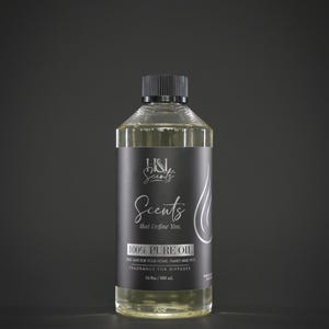 May include: A clear glass bottle with a black cap and a black label. The label reads "H&L Scents" and "100% Pure Oil". The bottle contains a light yellow liquid. The text "that Define You" is also on the label. The bottle is 500 ml.