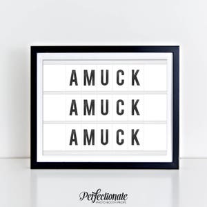 May include: A black framed sign with white background and the word "AMUCK" repeated three times in black letters.