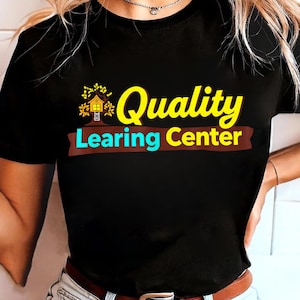 Könnte beinhalten: Schwarzes T-Shirt mit den Worten "Quality Learning Center" in Gelb und Blau, mit einer Baumhaus-Grafik. Der Text befindet sich über einem braunen Banner. Das T-Shirt wird von einer Person getragen.