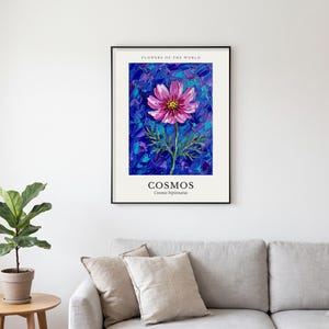 Può includere: Una stampa artistica incorniciata intitolata FLOWERS OF THE WORLD che raffigura un fiore di cosmea rosa con il centro giallo. Lo sfondo è composto da pennellate spesse e materiche blu e viola. Il testo riporta COSMOS e Cosmos bipinnatus.