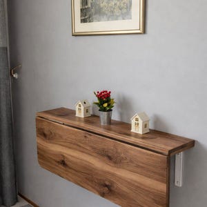 Escritorio plegable de pared con estantes, diseño moderno que ahorra espacio.