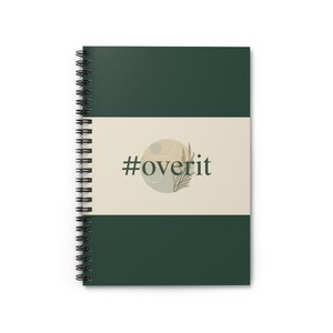 Pode incluir: Caderno espiralado com capa verde escuro e uma faixa horizontal creme. A faixa apresenta o texto "#overit" em fonte verde escuro, com um design circular e detalhes botânicos.