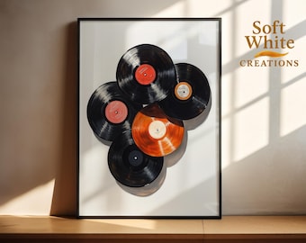 May include: Framed art print featuring a collection of vinyl records. The records are black with various colored labels, including red and orange. The artwork is set against a white background and framed in a black border. The text "Soft White Creations" is in the upper right corner.