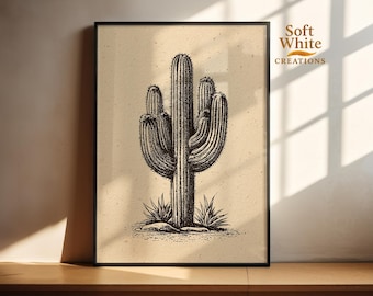 May include: Black and white illustration of a saguaro cactus in a black frame. The artwork features detailed linework, showcasing the cactus's form and texture. The background is a light beige, and the artwork is labeled "Soft White Creations."