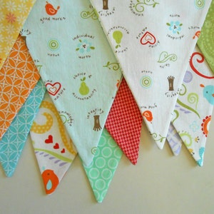 Peut inclure: Un ensemble de dix fanions en tissu avec différents motifs et couleurs. Les fanions sont décorés de divers motifs, notamment des fleurs, des oiseaux, des poires et des arbres. Les fanions sont cousus ensemble pour créer une guirlande.