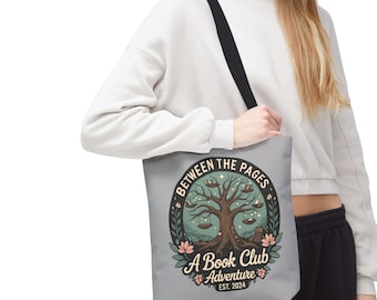 Może przedstawiać: Szara torba typu tote z czarnym paskiem na ramię. Torba posiada okrągły wzór z napisem "Between the Pages" i "A Book Club Adventure Est. 2024". Wzór zawiera drzewo z książkami i huśtawkami.