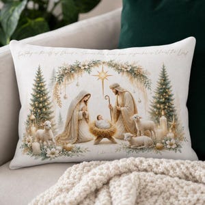 Könnte beinhalten: Ein rechteckiges Dekokissen mit einer Krippenszene, die eine zentrale Krippe, Figuren in Gewändern und Lämmer zeigt. Das Design umfasst zwei Weihnachtsbäume, einen Stern und den Text For today in the city of David a Savior has been born to you he is Christ the Lord.