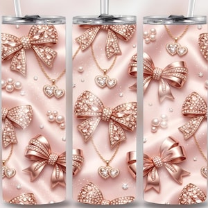 Puede incluir: Un juego de tres vasos de acero inoxidable con un diseño de lazo y joyas en color rosa. El diseño presenta lazos de oro rosa, colgantes en forma de corazón, perlas y detalles brillantes sobre un fondo de satén rosa. Cada vaso tiene una tapa plateada y una pajita.