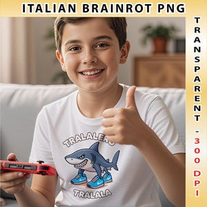Pode incluir: Uma camiseta branca com um tubar&atilde;o de desenho animado usando t&ecirc;nis azuis e o texto "TRALALERO TRALALA". A pessoa est&aacute; segurando um controle de jogo vermelho e dando um joinha.