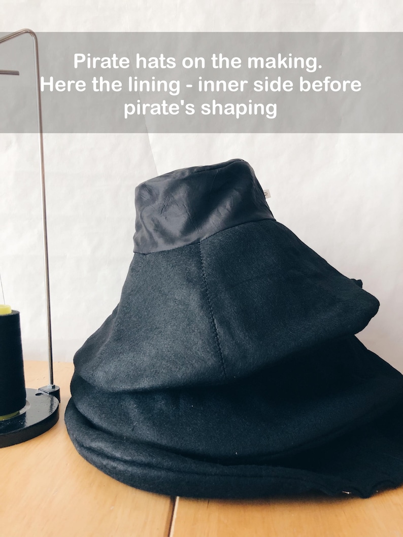 May include: Black pirate hats in various stages of construction. The hats are stacked, showing the lining and the shaping process. The text on the image reads: "Pirate hats on the making. Here the lining - inner side before pirate's shaping."