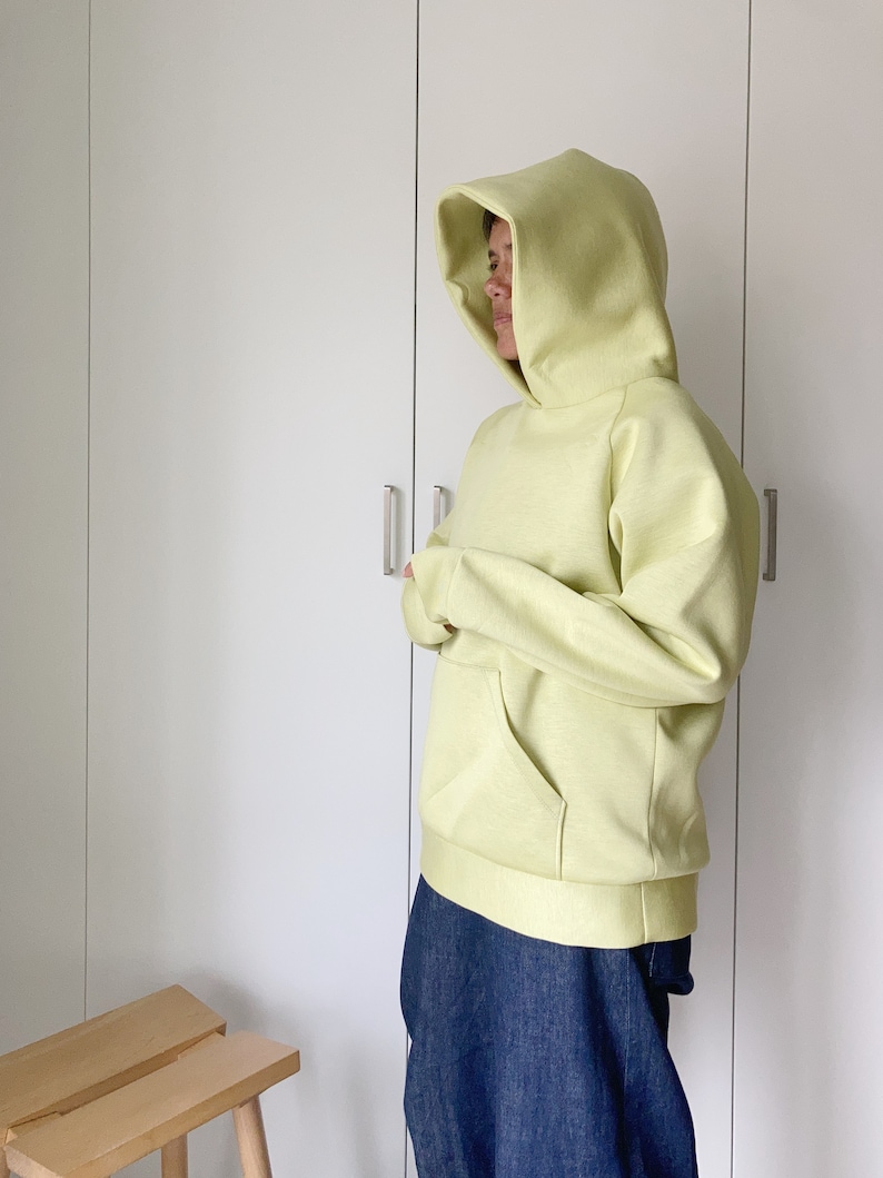 Woman wearing an oversize hoodie. Without logos. Color citric yellow