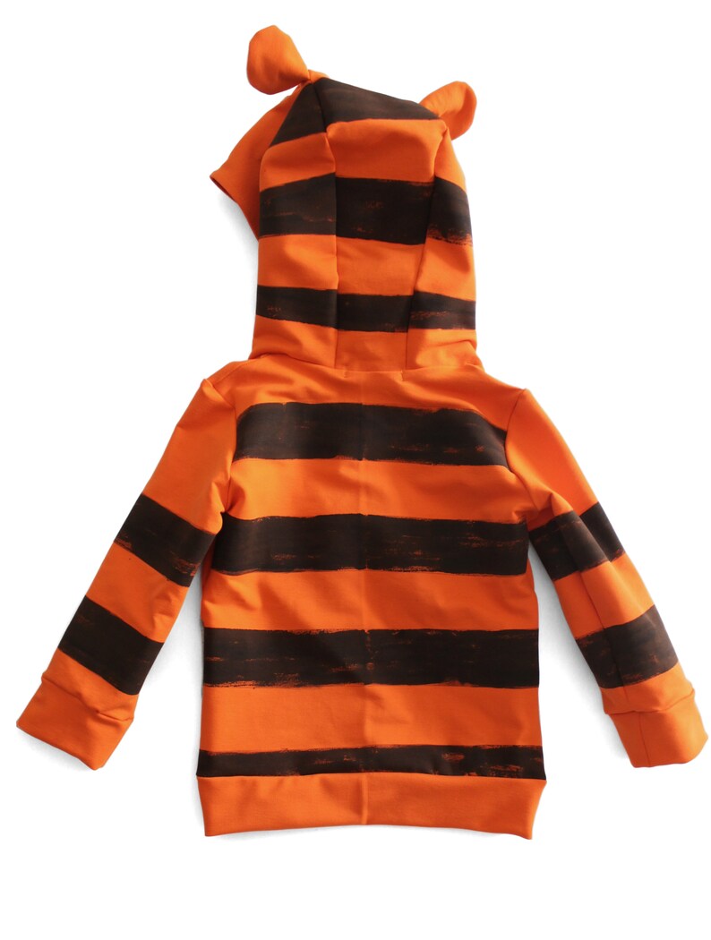 May include: Orange and black striped hooded sweatshirt with attached ears. The sweatshirt features a full-length zipper and ribbed cuffs. The design resembles a tiger.