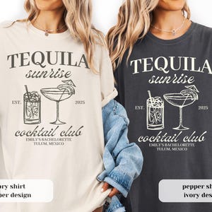 Puede incluir: Camisetas color marfil y pimienta con un diseño de "Tequila Sunrise Cocktail Club". El diseño incluye ilustraciones de cócteles, el texto "EST. 2025" y "Emily's Bachelorette Tulum, Mexico".