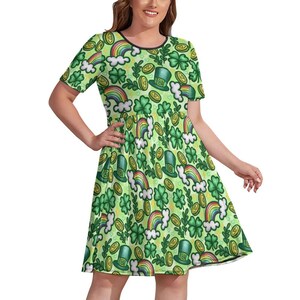May include: A green dress patterned with St. Patrick's Day motifs, including rainbows, shamrocks, gold coins, and leprechaun hats. The dress has short sleeves and a black trim around the neckline.