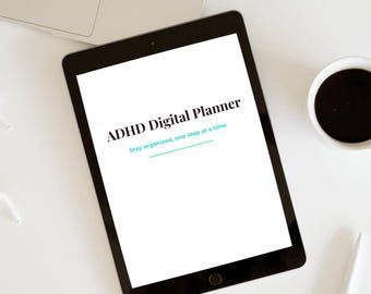 May include: A black tablet displaying "ADHD Digital Planner" with the tagline "Stay organized, one step at a time." The tablet is on a white surface, next to a laptop, a pen, and a cup of coffee.