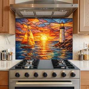 Op de afbeelding: Een kleurrijke keukenachterwand met een zonsondergang in glas-in-loodstijl. De afbeelding toont een zeilboot op het water, een vuurtoren en een grote zon. De lucht is een mix van oranje, rood en blauw, waarbij het water de zonsondergang weerspiegelt.