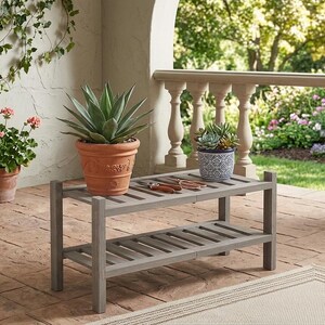 Puede incluir: Un banco de madera gris de dos niveles con una planta suculenta en maceta y unas tijeras de podar. Una gran planta de agave en maceta se encuentra en el banco. Otras plantas en maceta y un jard&iacute;n est&aacute;n en el fondo.