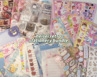 May include: A collection of colorful stationery items, including stickers, notepads, and decorative papers. The bundle features a variety of designs, such as cute animals, cakes, and Japanese text. The text "heisei retro stationery bundle" is visible.