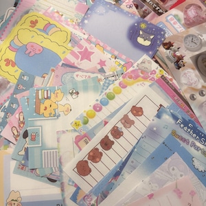 May include: A selection of colourful stationery, including notepads and stickers, with diverse designs. The designs feature cartoon animals, stars, and floral patterns. The colour palette includes pastel pinks, blues, and yellows.