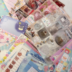 May include: A selection of colourful stationery, including stickers and notepaper, with cute illustrations of animals, food, and other decorative elements. Some items have Japanese text.