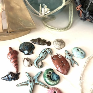 Conjunto de botões de cerâmica artesanais com tema marítimo.