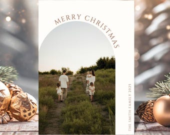 May include: A Christmas card with a family photo inside an arch. The words "MERRY CHRISTMAS" are arched above the photo. The family is walking on a path through tall grass. The text "THE SMITH FAMILY 2025" is printed vertically on the right side.