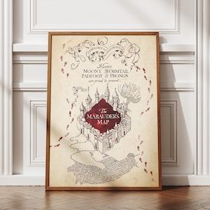May include: A framed print of The Marauder's Map from the Harry Potter series. The map features a detailed illustration of Hogwarts Castle, footprints, and handwritten text. The frame is a warm brown color, and the print has a vintage, parchment-like appearance.