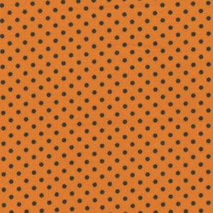 May include: Orange fabric featuring a repeating pattern of small, dark grey polka dots. A ruler is printed along the bottom edge. The word "moda" and the website address "www.modafabrics.com" are printed on the bottom.