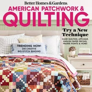 Op de afbeelding: Een tijdschriftcover voor het tijdschrift American Patchwork & Quilting. De cover toont een quilt met een patchwork-ontwerp in tinten rood, bruin, blauw en groen. De tekst op de cover luidt "Probeer een nieuwe techniek" en "Trend nu: Decoratieve grote steek binding".