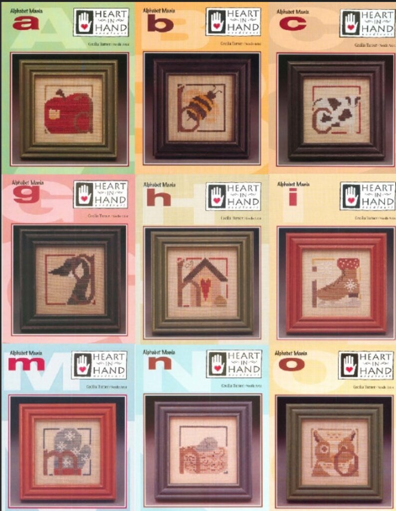 Puede incluir: Una colecci&oacute;n de bordados de punto de cruz enmarcados con varios dise&ntilde;os, incluyendo una manzana, una abeja y una vaca. Cada bordado est&aacute; en un marco cuadrado con un borde oscuro. El texto "Alphabet Mania" y "Heart in Hand" es visible.
