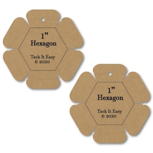 Pode incluir: Duas peças hexagonais de cartão castanho, cada uma com uma medida de 2,54 cm e o texto "Hexagon". O texto "Tack It Easy © 2020" também está impresso em cada peça. Cada peça tem um pequeno orifício na parte superior.