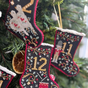 New ANNIE BeEZ FOLK ArT 12 Days of Christmas Stockings counted cross stitch patterns at cottageneedle.com 2024 Nashville Market image 1