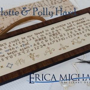 May include: A framed cross-stitch sampler with the text "Christ's cross be my Speed in all virtue to proceed." The sampler is in a dark wood frame. The image also includes the text "Charlotte & Polly Hard" and "Erica Michaels Needleart Designs."