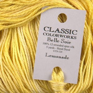 May include: A skein of yellow hand-dyed silk thread labeled "CLASSIC COLORWORKS Belle Soie 100% 12-stranded spun silk 5 yards - Hand Dyed CCS-120 Lemonade"