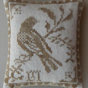 May include: A white pillow with a brown embroidered bird and a leafy branch design. The pillow has a brown border and the word "Erin" embroidered in the center.