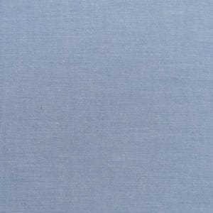 Op de afbeelding: Close-up van een lichtblauwe stof met een getextureerde weefsel. De stof heeft een subtiele glans en de kleur is een zacht, gedempt blauw. Het weefpatroon is zichtbaar, waardoor een enigszins ruwe textuur ontstaat.