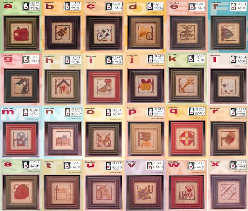 Puede incluir: Una colecci&oacute;n de muestras de punto de cruz enmarcadas, cada una con una letra del alfabeto y una imagen correspondiente. Los marcos son de varios colores, con el texto "HEART IN HAND" visible.