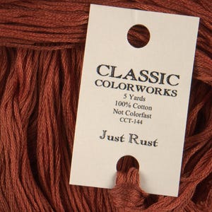May include: A spool of Just Rust embroidery floss, a deep reddish-brown color, with a white label that reads "Classic Colorworks", "5 Yards", "100% Cotton", "Not Colorfast", "CCT-144", and "Just Rust".